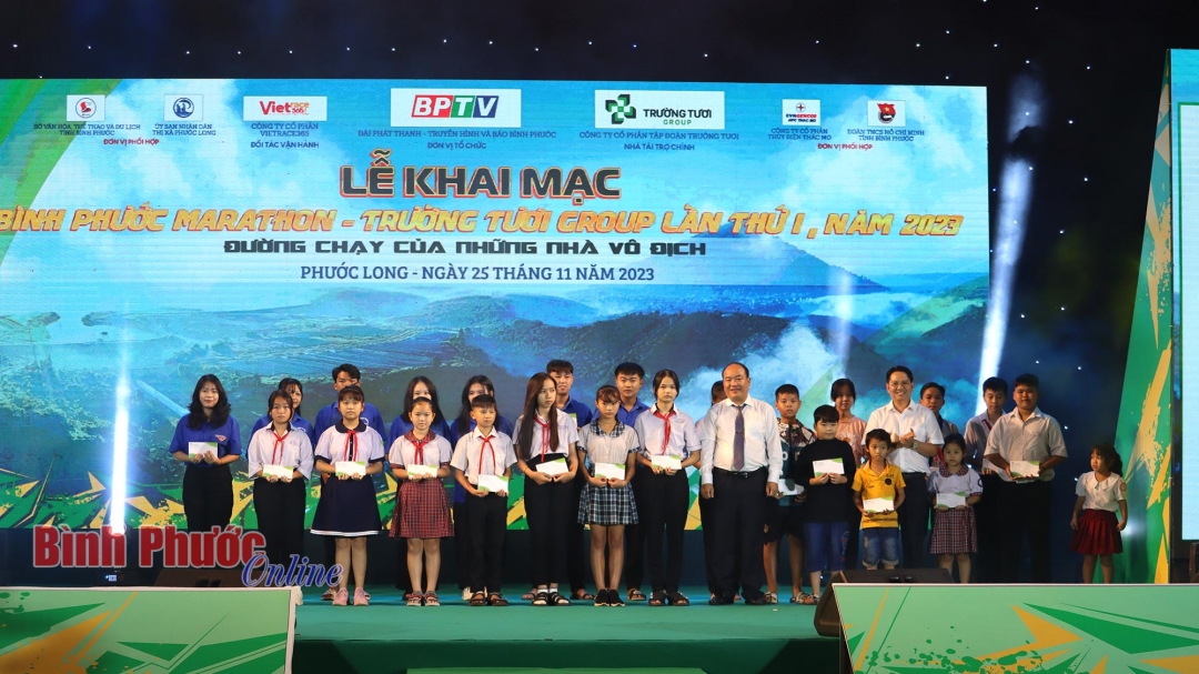 Ban tổ chức trao tặng 30 suất học bổng, khích lệ tinh thần vượt khó học tốt cho 30 học sinh thị xã Phước Long - Ảnh: Văn Đoàn
