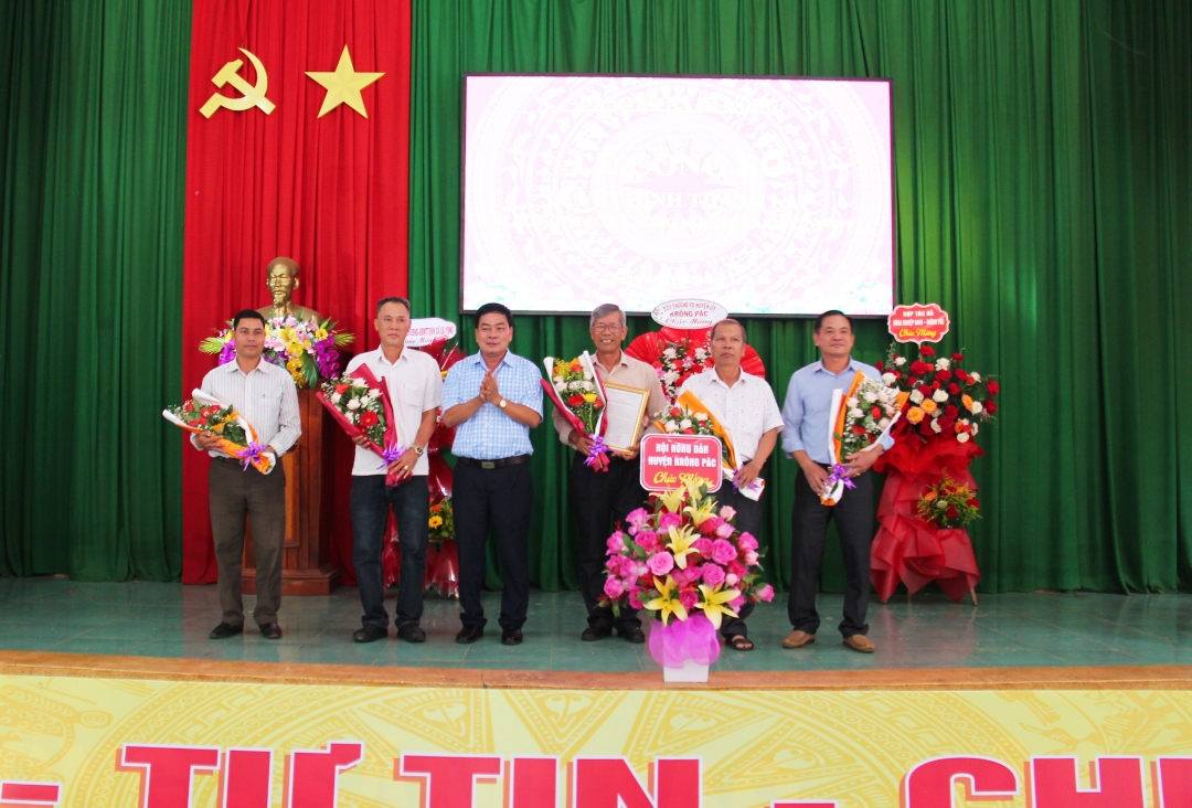 Bí thư Đảng ủy xã Ea Yông Phan Đính tặng hoa chúc mừng Chi bộ HTX Nông nghiệp xanh Krông Pắc trong lễ ra mắt.