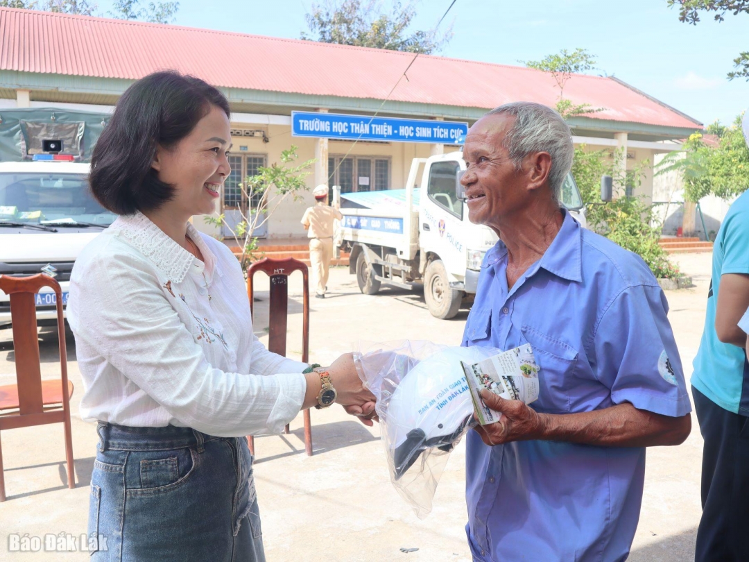 Đại diện Văn phòng Ban An toàn giao thông tỉnh tặng mũ bảo hiểm cho người dân.