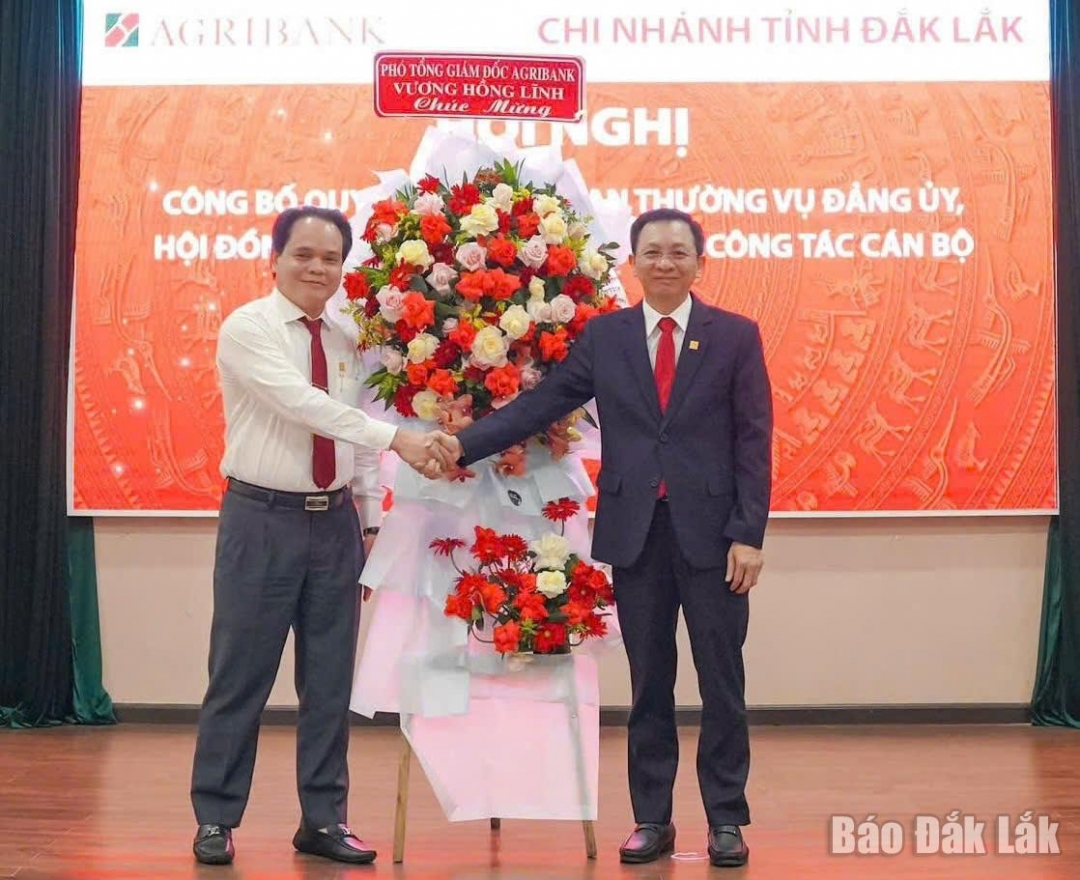 Phó Tổng Giám đốc Agribank Vương Hồng Lĩnh tặng hoa chúc mừng ông Lê Văn Thịnh.