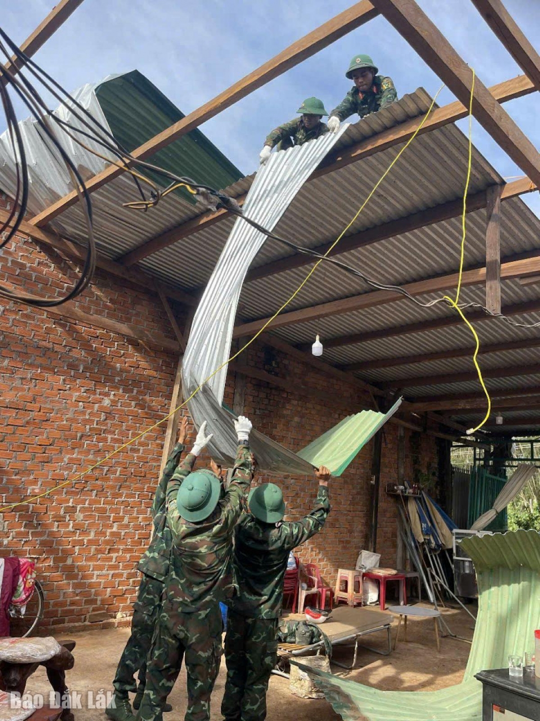 Chiến sĩ Trung đoàn 66 giúp dân lợp lại nhà ở. Ảnh: Anh Thương