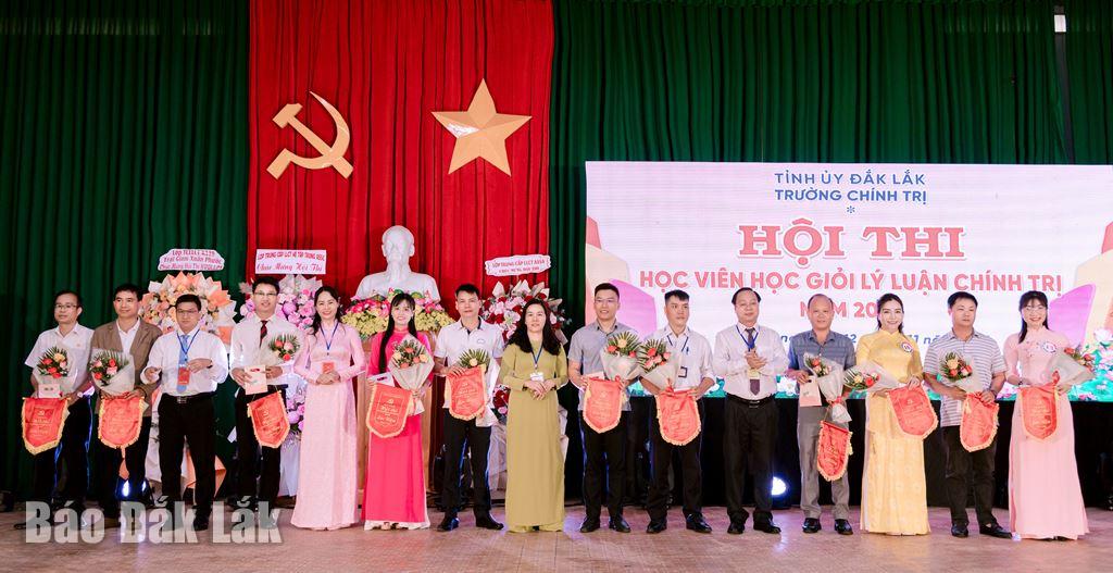 Học viên tham gia hội thi nhận cờ lưu niệm và hoa của Ban tổ chức hội thi trao tặng.