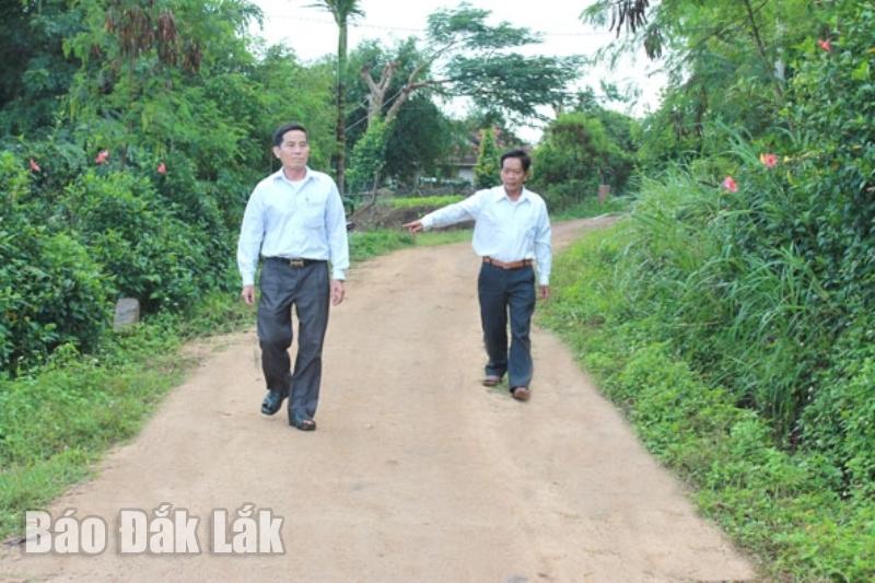 Ông Hà Xuân Đẹt (bên trái) chia sẻ cách tuyên truyền, vận động bà con thôn Thanh Bình, xã Ea Knốp đóng góp xây dựng đường giao thông trong thôn. Ảnh: N. Xuân