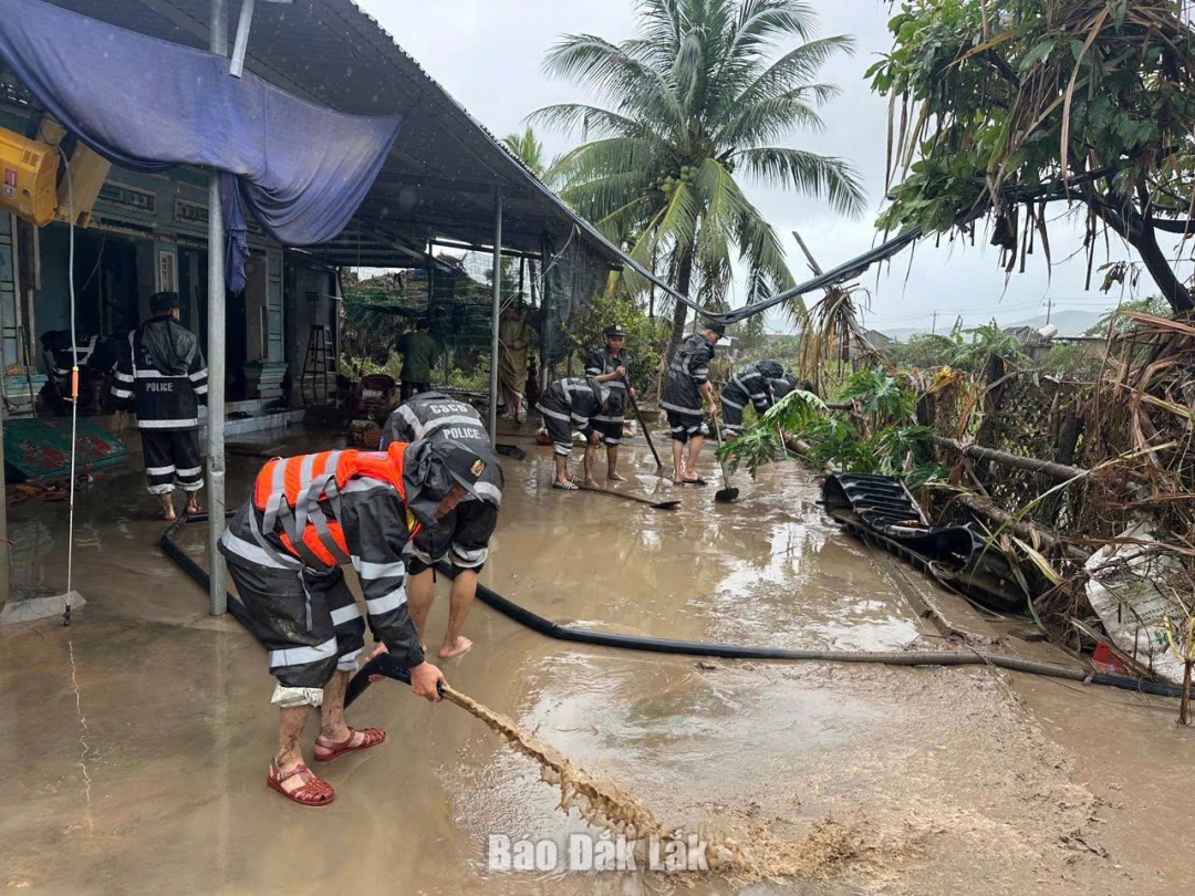Lực lượng cảnh sát cơ động hỗ trợ người dân dọn dẹp nhà cửa sau lũ.