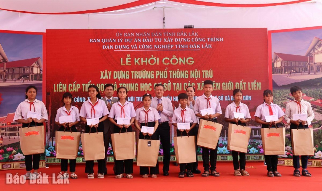 Lãnh đạo tỉnh và lãnh đạo xã Buôn Đôn trao quà tặng các em học sinh.