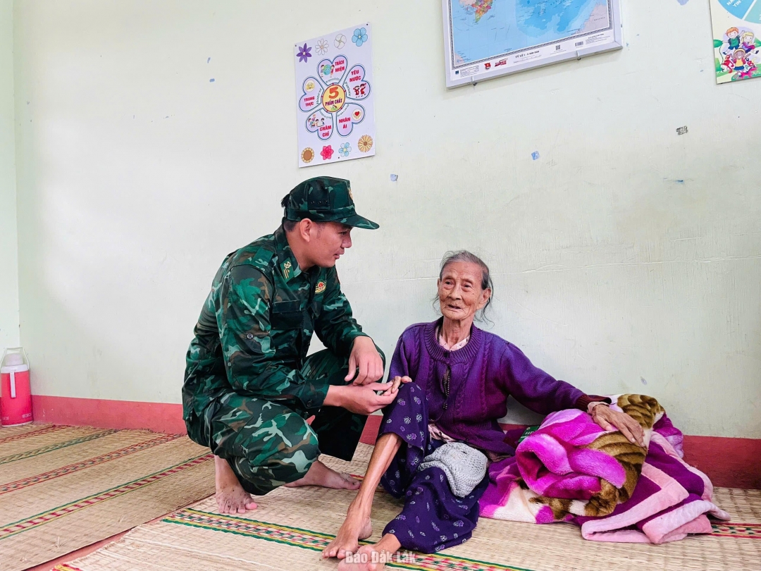 Cán bộ, chiến sĩ Đồn biên phòng Xuân Đài thăm hỏi, động viên bà con tổ dân phố Long Phước, phường Sông Cầu đang tránh trú bão số 13 tại Trường tiểu học Xuân Phú. Ảnh: Hà My