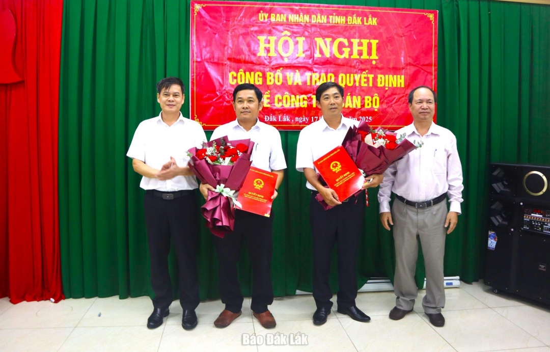 giám đốc Sở Nội vụ Trương Ngọc Tuấn và Phó Bí thư Đảng ủy UBND tỉnh Nguyễn Hữu Việt trao quyết định và tặng hoa chúc mừng tân Giám đốc Ban Quản lý dự án đầu tư xây dựng Ea Kar và Buôn Hồ.