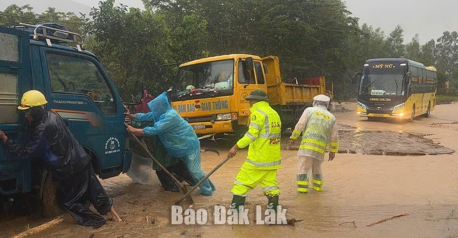Đội CSGT Đường bộ số 2 hỗ trợ phương tiên lưu thông qua vị trí ngập nước trên Quốc lộ 29.
