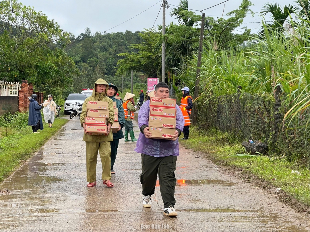 Lực lượng chức năng hỗ trợ nhu yếu phẩm cho người dân bị cô lập do mưa bão tại xã Dray Bhăng.