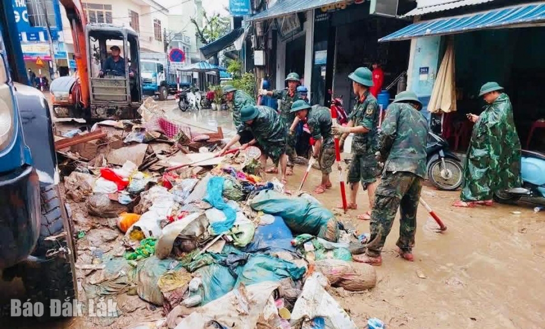 Lực lượng quân đội giúp xã Đồng Xuân thu dọn rác và bùn đất sau khi nước rút.