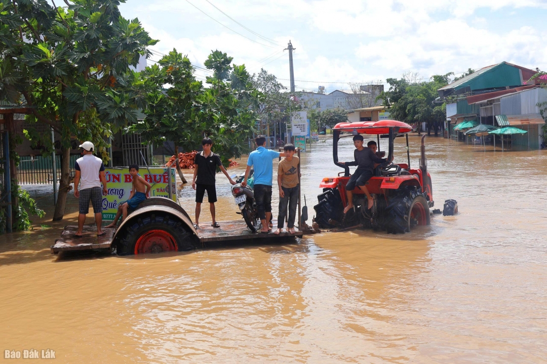 Người dân di chuyển bằng xe máy cày qua các vùng ngập.