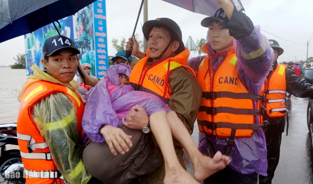 Lực lượng công an bớ một người già ở xã Hòa Thịnh từ trên ca nô xuống để đưa lên xe ra bệnh viện chăm sóc sức khỏe. Ảnh: Trung Hiếu