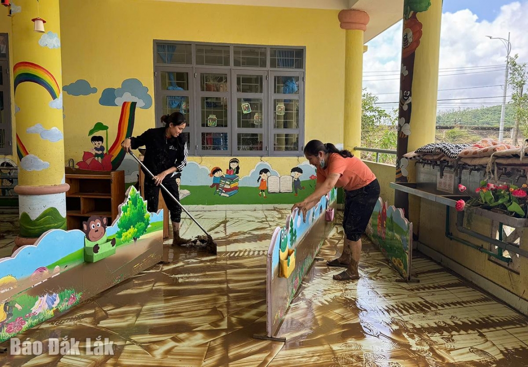 Giáo viên Trường tiểu học An Định (xã Tuy An Bắc) tranh thủ dọn bùn khi nước lũ rút.
