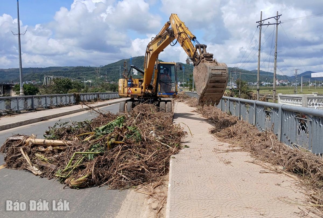 Chính quyền địa phương xử dụng xe cơ giới dọn bùn, đất, rác trên cầu La Hai.