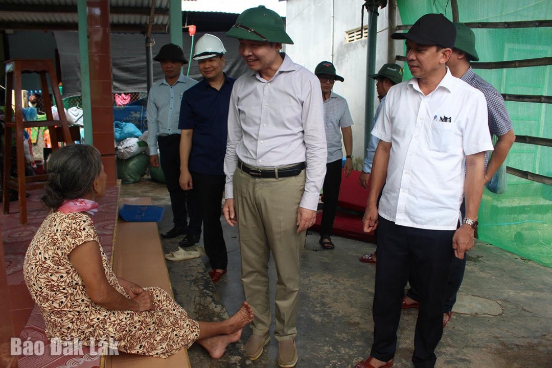 Đồng chí Tạ Anh Tuấn động viên gia đình bà Huỳnh Thị Bảy ở khu phố Mỹ Thành, phường Xuân Thành - nhà bị tốc mái do bão số 13.