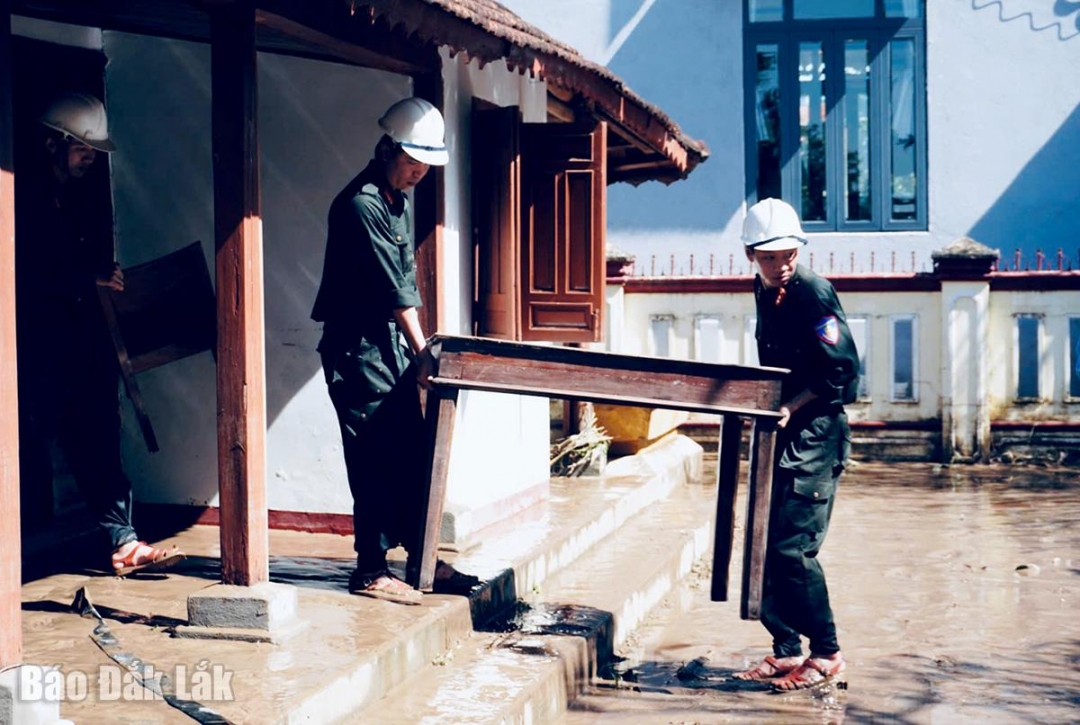 Lực lượng công an tỉnh cùng địa phương dọn dẹp bàn ghế, bùn đất tại Di tích nơi thành lập chi bộ Đảng đầu tiên.