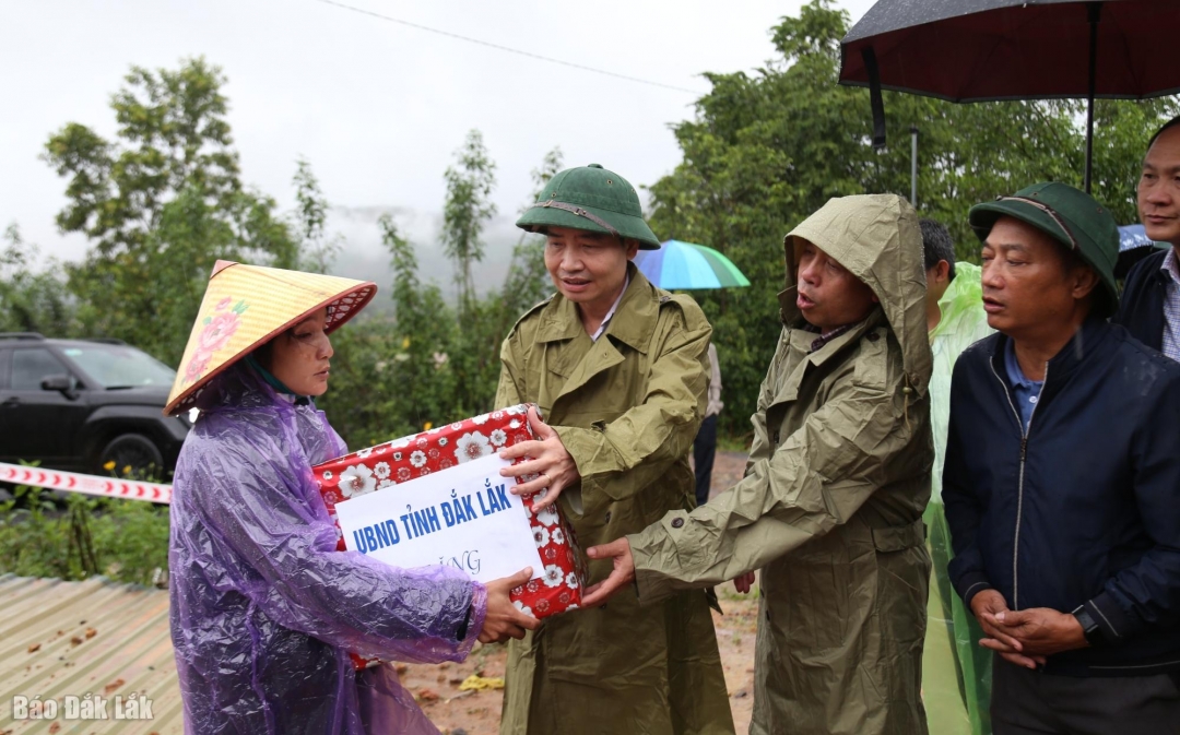 Chủ tịch UBND tỉnh Tạ Anh Tuấn tặng quà cho hộ gia đình bị sập nhà do sạt lở đất. Ảnh: Thuận Thông