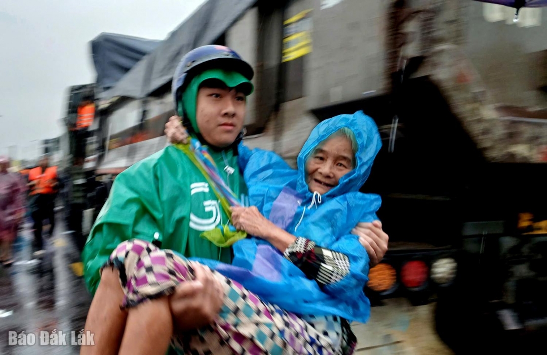 Một cụ già ở Hòa Thịnh được người thân đưa đến nơi an toàn khi được lực lượng chức năng cứu khỏi vùng lũ. Ảnh: Trung Hiếu