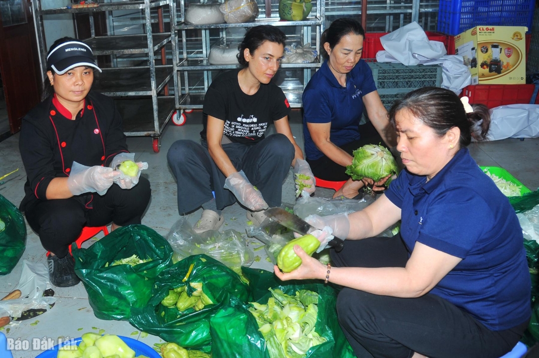 Du khách người Đức (thứ 2 từ trái qua) tham gia cùng với nhóm thiện nguyện tổ chức nấu cơm hỗ trợ bà con bị ảnh hưởng lũ lụt.