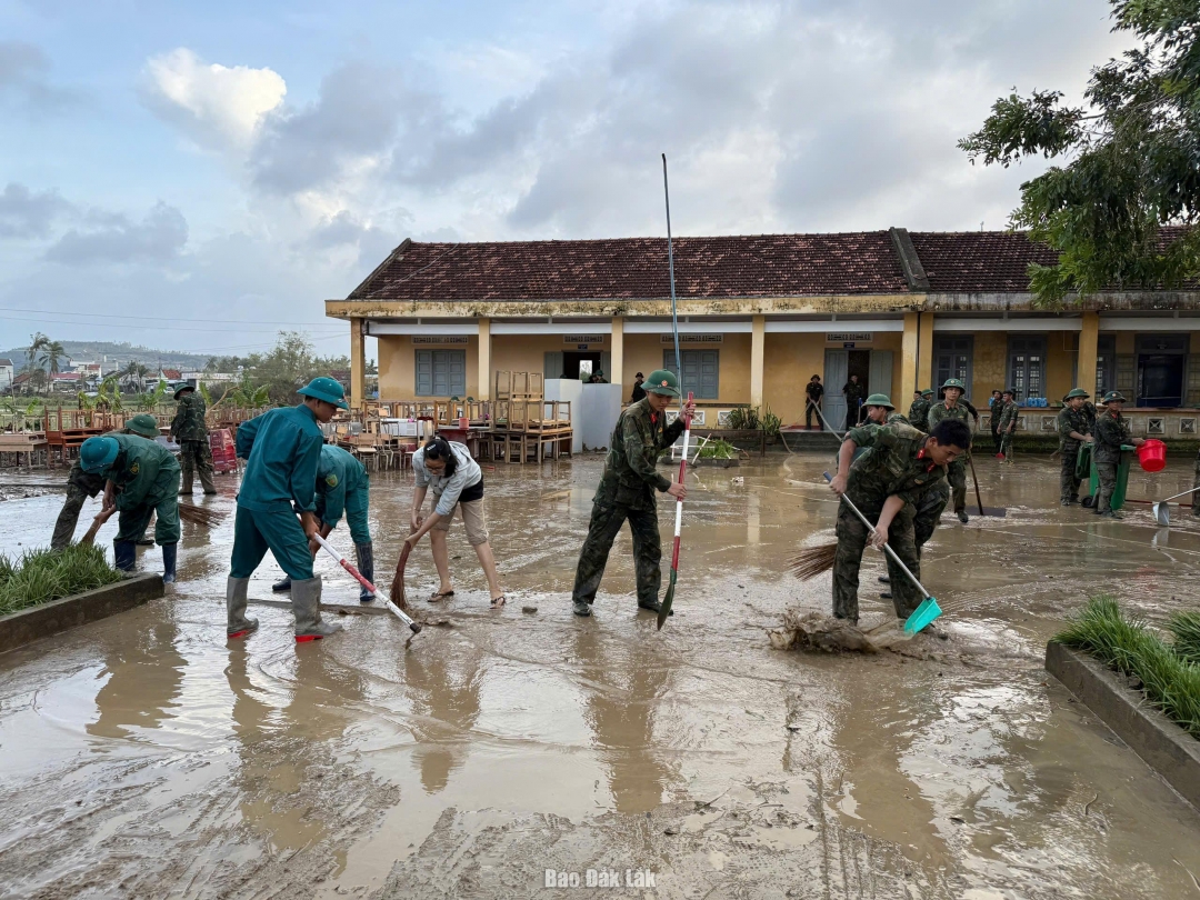 Lực lượng quân đội hỗ trợ dọn bùn tại Trường tiểu học An Ninh Tây. Ảnh: Hà My