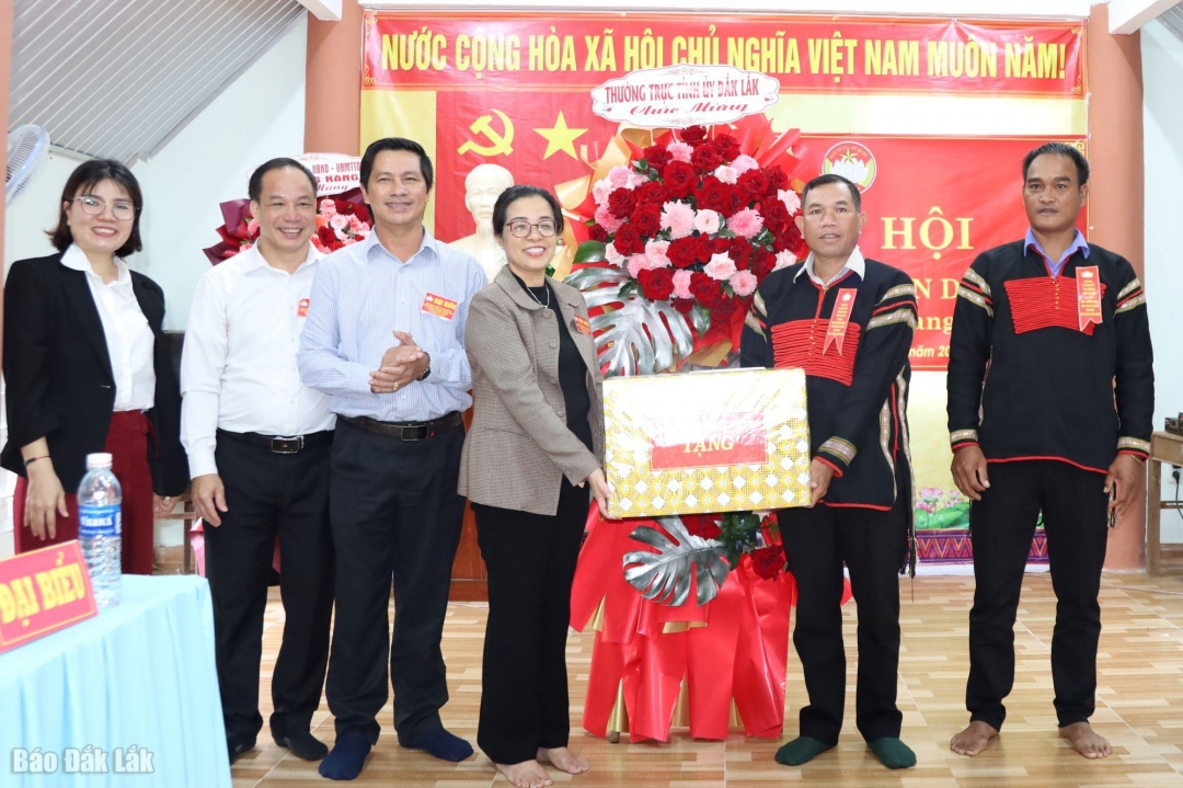 Phó Bí thư Tỉnh ủy Huỳnh Thị Chiến Hòa tặng quà và hoa chúc mừng buôn Cư Păm.