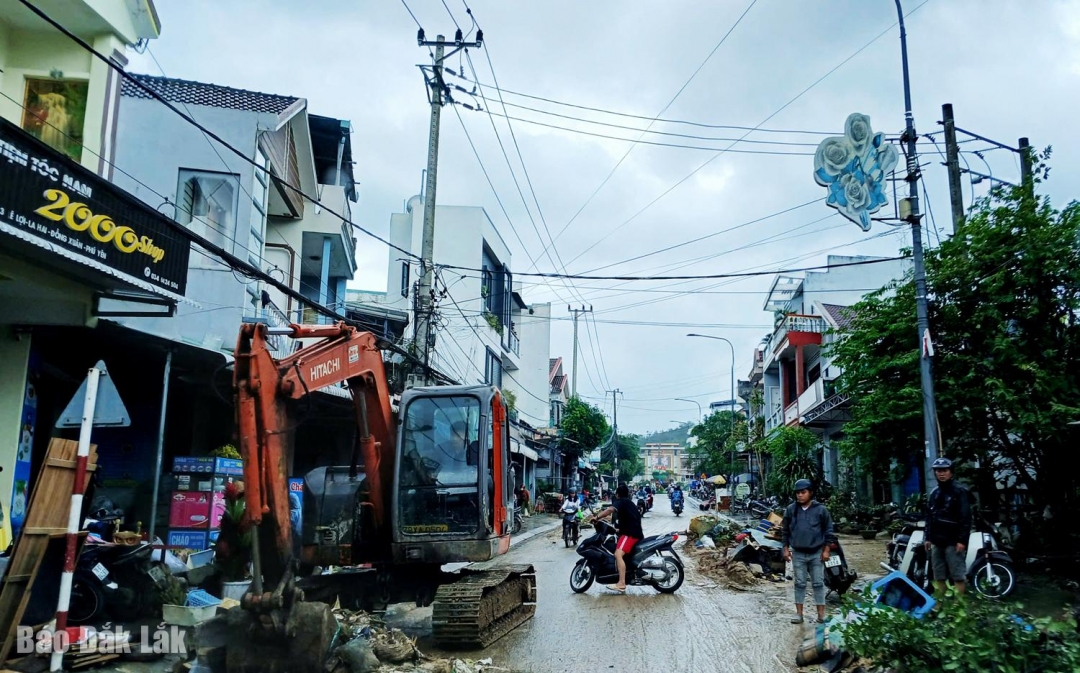 Xã Đồng Xuân xử dụng xe múc nạo vét bùn, rác tại đường Lê Lợi do lũ gây ra. Ảnh: Trung Hiếu 