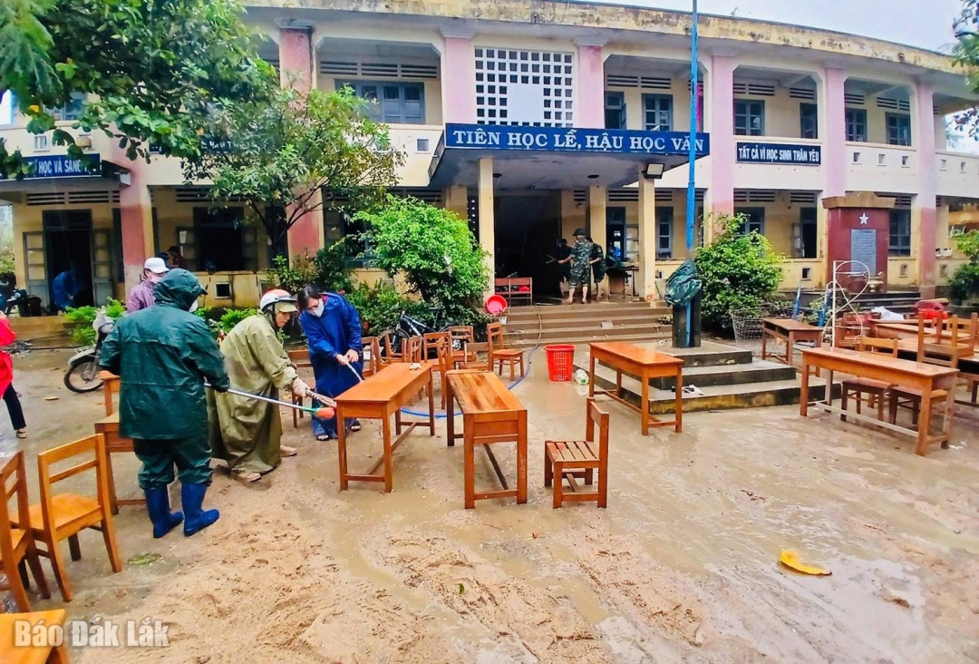 Nỗ lực dọn rửa bàn ghế để sớm cho học sinh đi học trở lại sau lũ.