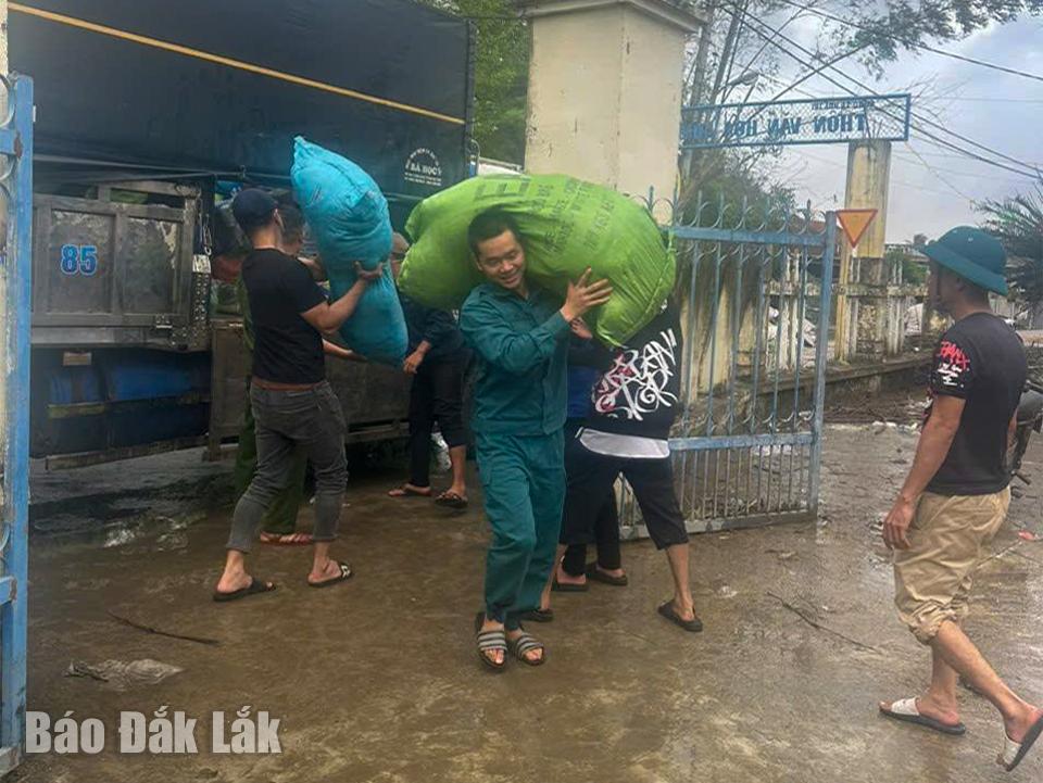 Các thành viên đoàn hỗ trợ của xã Ea Knuếc chuyển hàng hóa đến điểm tập kết tại xã Phú Hòa 2.