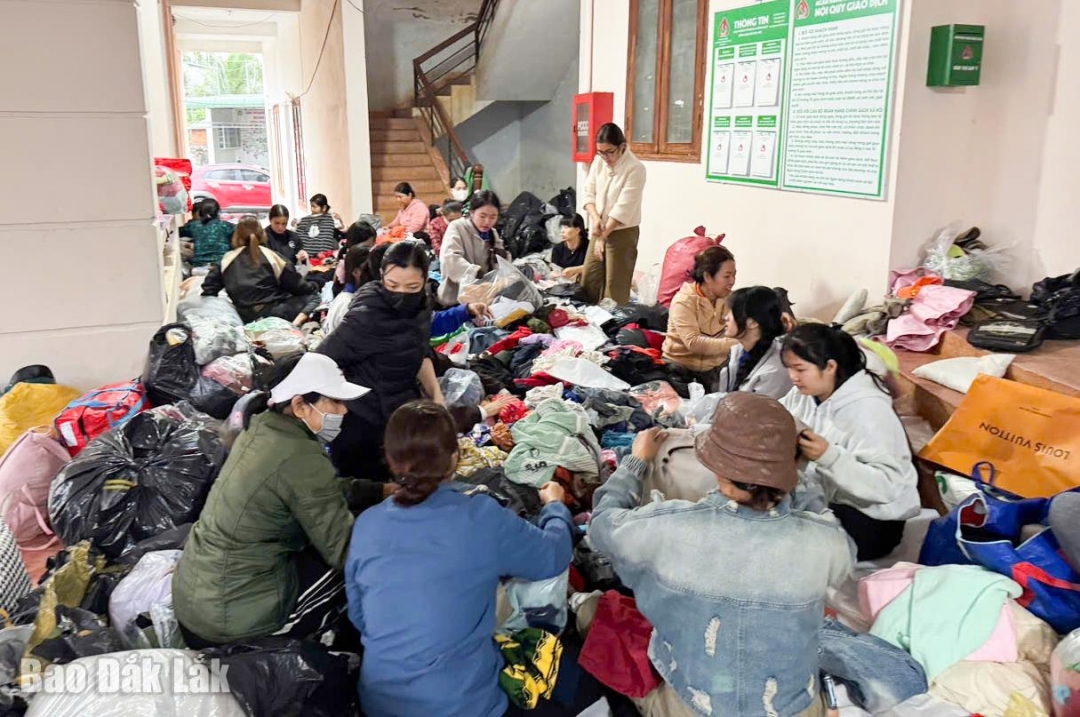 Cán bộ và người dân xã Ea Phê cùng tham gia phân loại quần áo cũ để gửi đến bà con vùng lũ những đồ dùng thật sự cấp thiết.