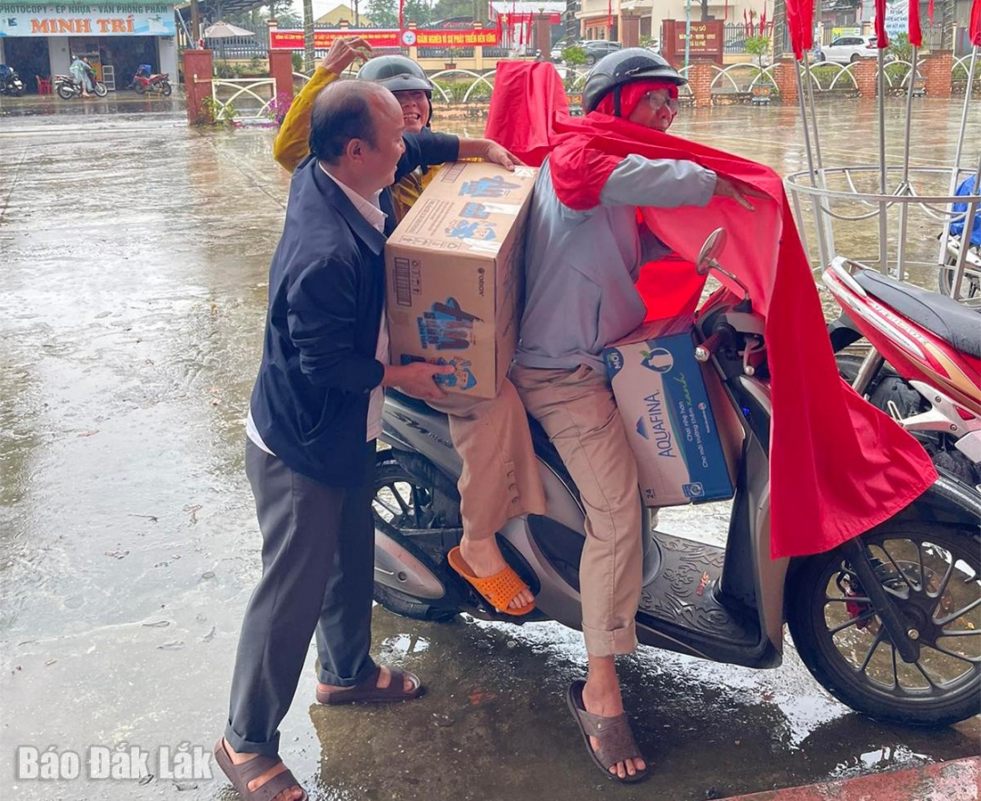 Người dân xã Ea Phê đội mưa mang nhu yếu phẩm đến Nhà văn hóa xã để ủng hộ đồng bào vùng lũ lụt.