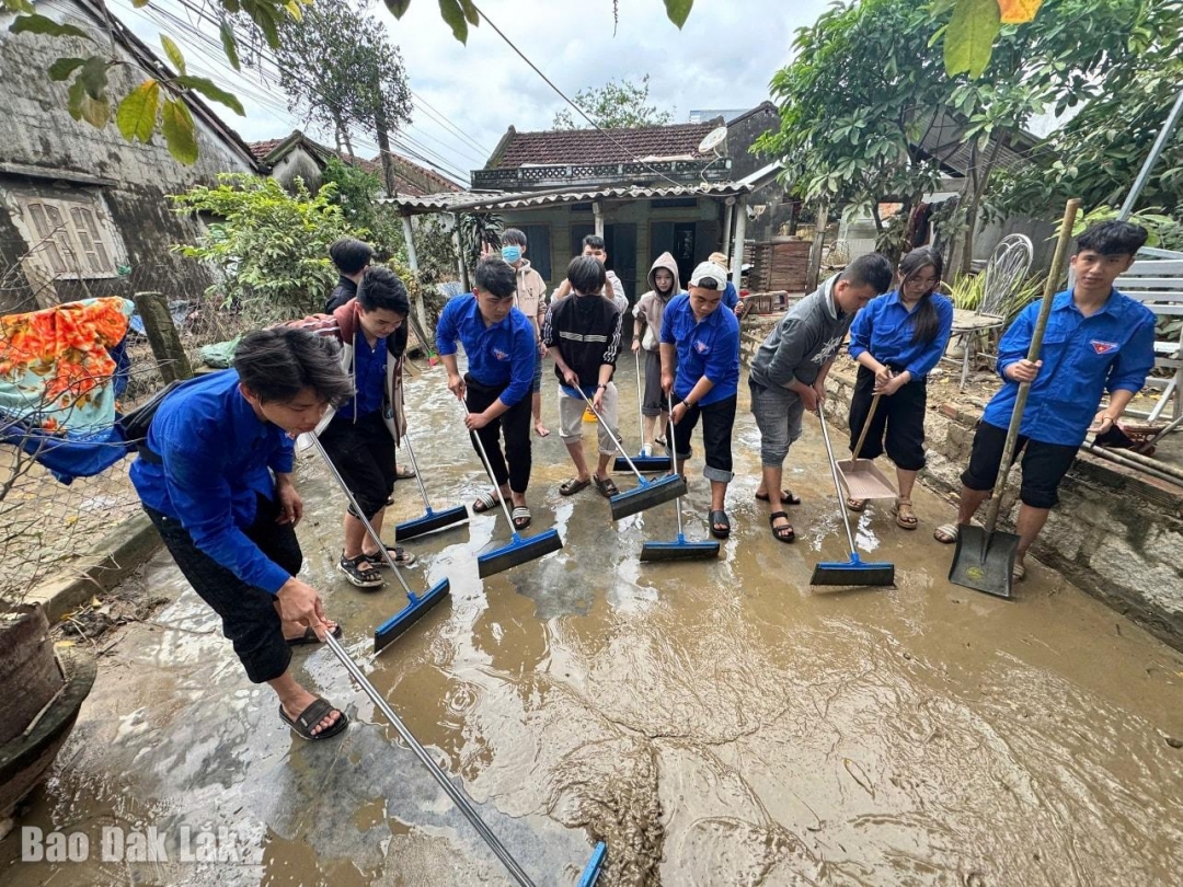 Đoàn viên thanh niên giúp người dân dọn dẹp nhà sau lũ.