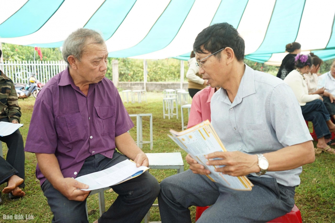 Cán bộ Bảo hiểm xã hội cơ sở Kroong Năng tuyên truyền chính sách bảo hiểm y tế đến người dân