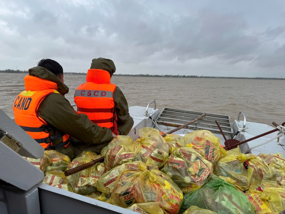 Lực lượng chức năng vận chuyển nhu yếu phẩm đến cho người dân bị chia cắt nhiều ngày do lũ.