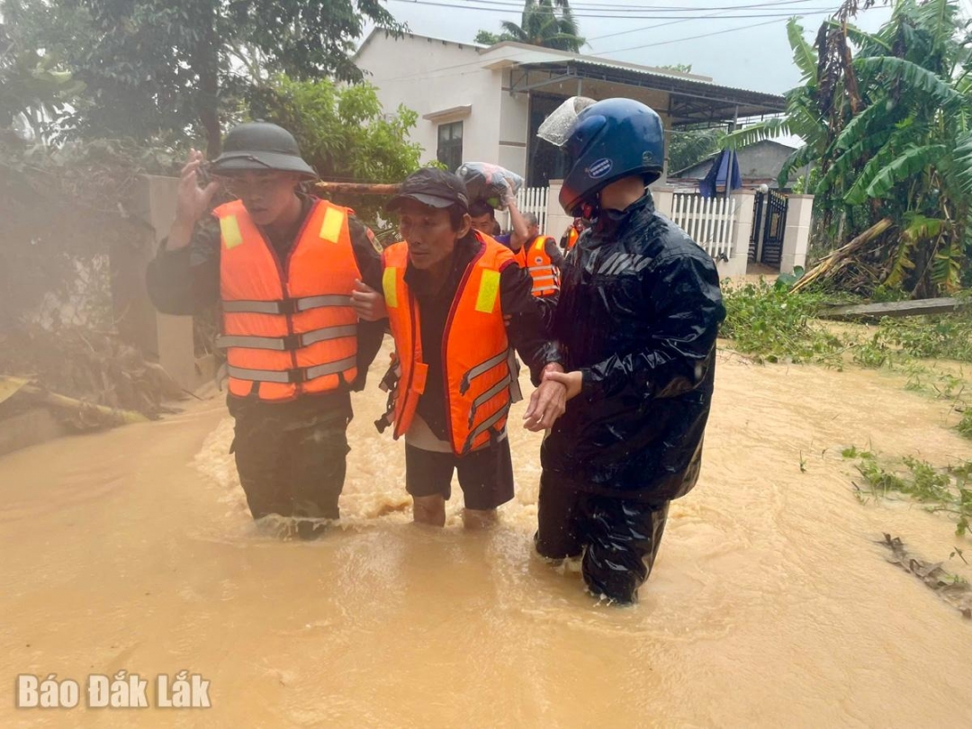 Lực lượng chức năng hỗ trợ người già yếu của địa phương đến nơi an toàn.