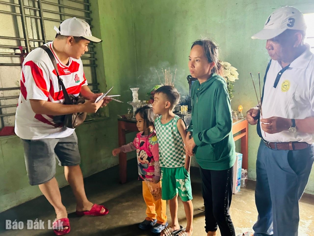 Ông Ngô Văn Định (phải), Phó Chủ tịch Hiệp hội Du lịch Đắk Lắk và nhưng người bạn Hà Nội tặng tiền hỗ trợ cho gia đình chị Bùi Thị Mai (xã hòa Thịnh), chồng bị chết trong cơn lũ dữ.