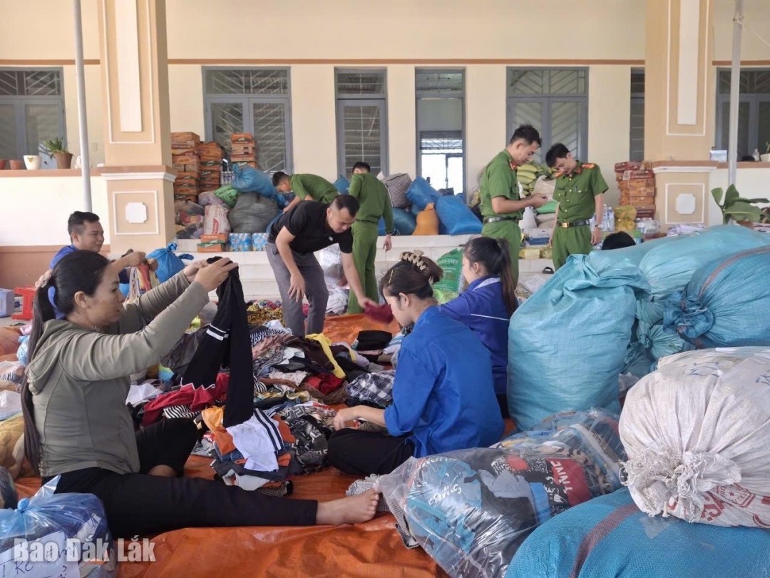 Công an xã Ia Rvê cùng với bà con nhân dân sắp xếp, phân loại và đóng gói quần áo trao tặng cho người dân bị ảnh hưởng bão lũ ở xã 