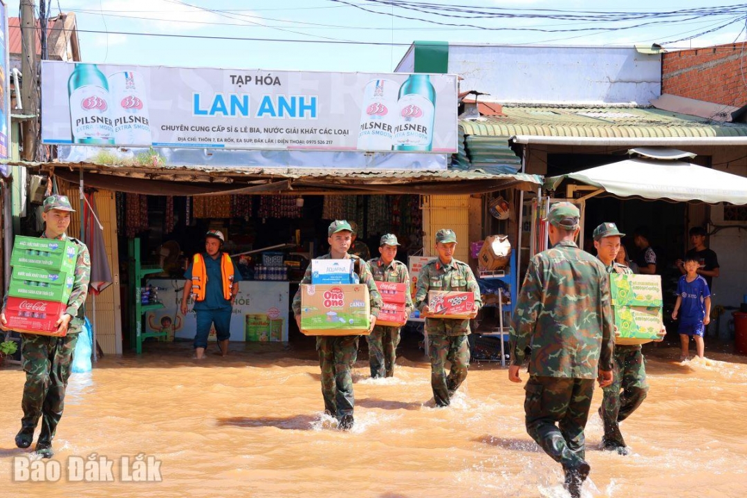 Cán bộ, chiến sĩ Ban Chỉ huy Khu vực Phòng thủ 3 - Ea Súp dầm nước, giúp bà con xã Ea Rốk di dời tài sản.