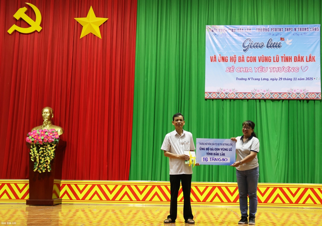 thầy Bùi Xuân Lễ, Hiệu trưởng Trường Phổ thông DTNT THPT N’Trang Lơng đã trao biển tượng trưng 16 tấn gạo cho Nhà văn Niê Thanh Mai, Chủ tịch Hội Văn học Nghệ thuật tỉnh Đắk Lắk. 