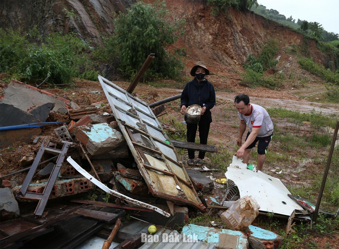 Vợ chồng anh Hoàng Văn Hiếu vợt vát ít vật dụng còn dùng được sau khi căn nhà bị sập hoàn toàn