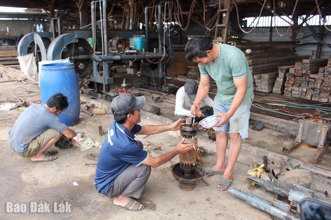 Công nhân làm việc tại một xưởng mộc ở thôn Vĩnh Phú, sửa chữa thiết bị bị hư hỏng.