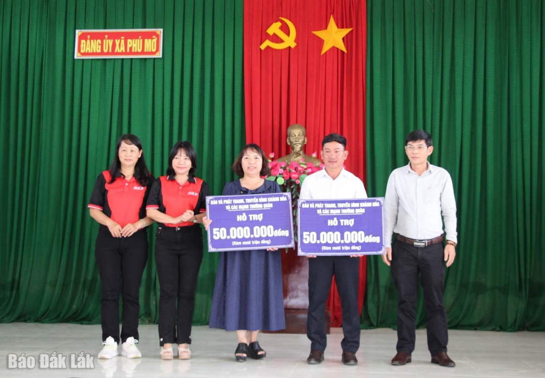 Đoàn công tác trao biểu trưng tặng tiền hỗ trợ cho hai trường.