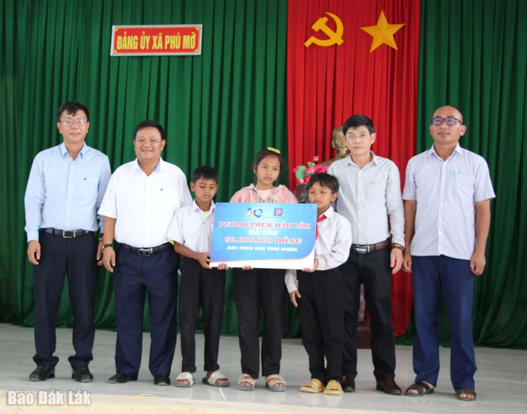 Đại diện các đơn vị trao biểu trưng tặng tiền hỗ trơ xây nhà cho các em. 