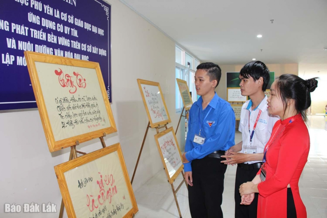 Các bạn sinh viên tham quan, tìm hiểu các tác phẩm thư pháp thơ viết về người thầy.