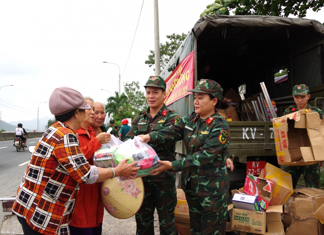 Cán bộ Bộ Chỉ huy Quân sự tỉnh trao các gói hàng cho người dân vùng lũ.