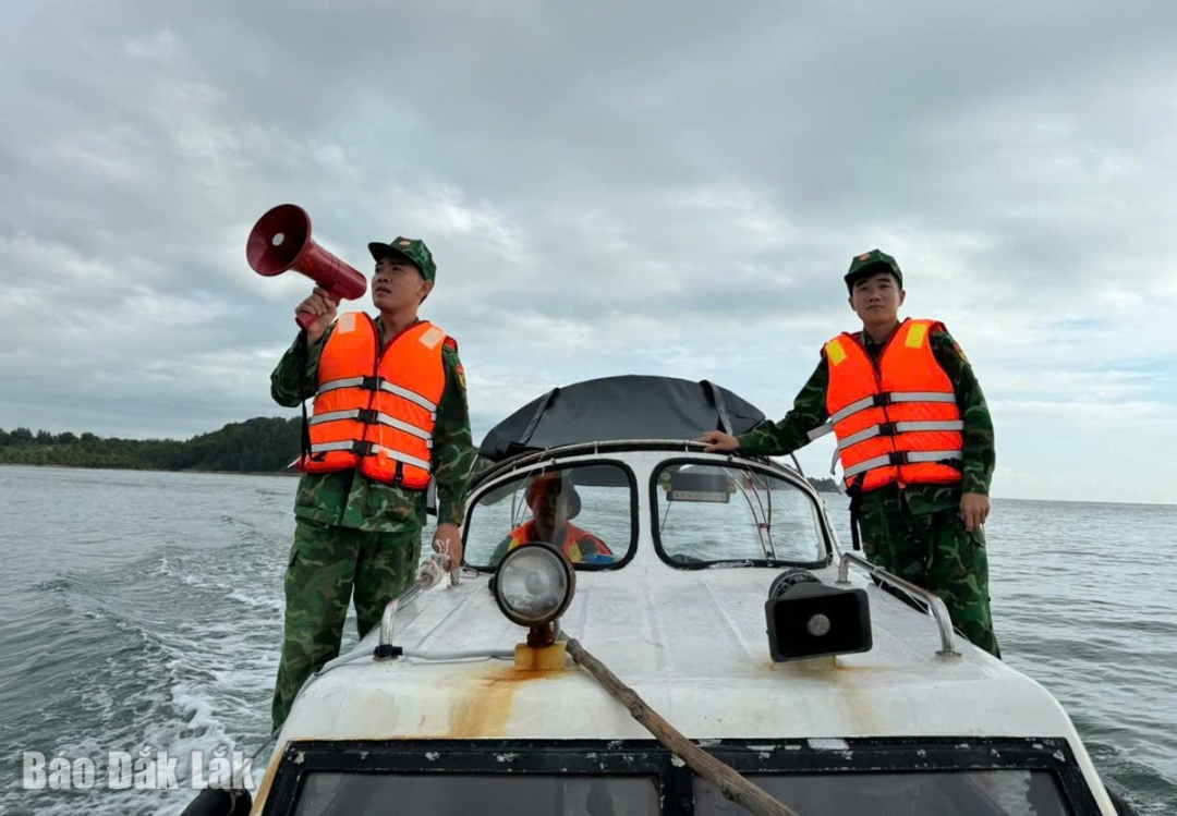 Cán bộ biên phòng dùng loa cầm tay kêu gọi người dân vào bờ tránh trú bão an toàn. Ảnh: Đăng Vũ