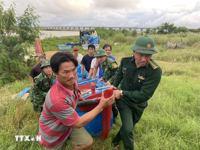 Lực lượng Đồn Biên phòng Tuy Hòa hỗ trợ người dân đưa tàu thuyền đến nơi an toàn. Ảnh: TTXVN
