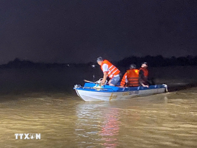 Các lực lượng chức năng giải cứu thành công nhiều người dân bị mắc kẹt giữa dòng nước lũ. Ảnh: TTXVN