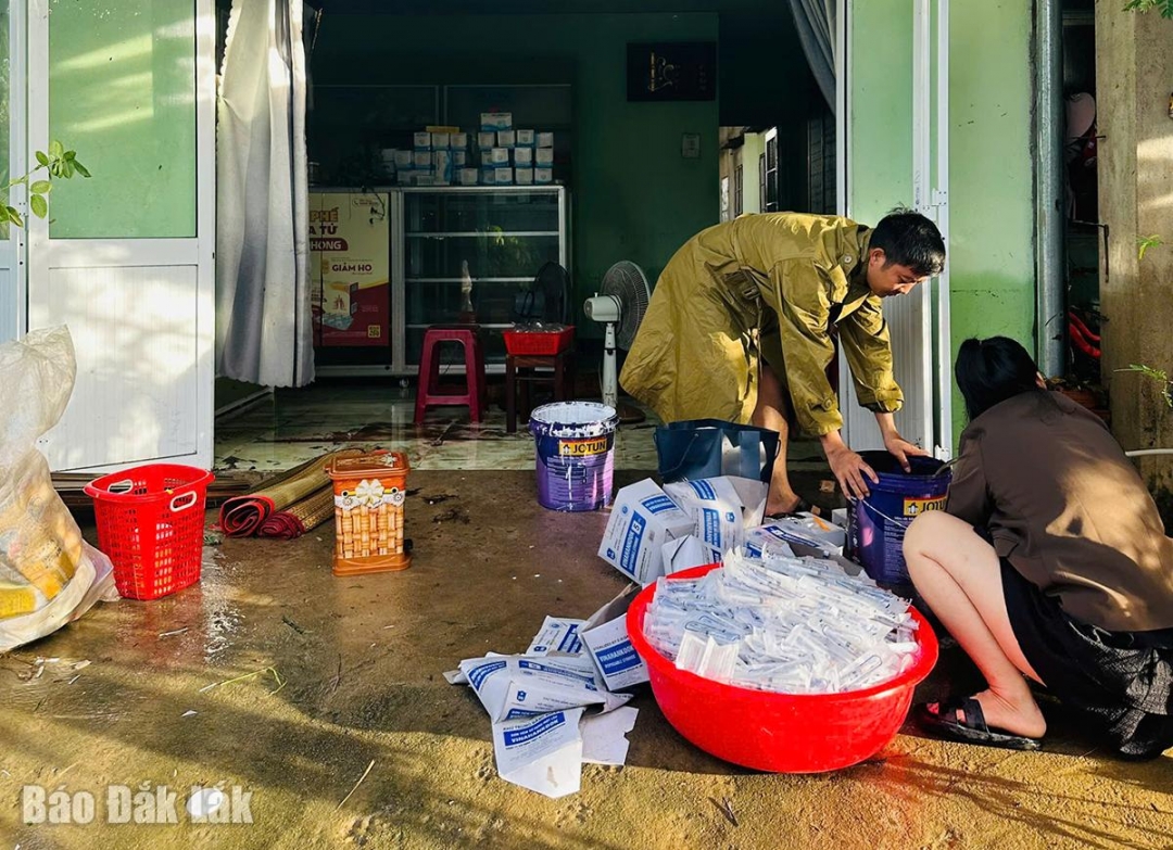 Cán bộ y tế xã Đồng Xuân hướng dẫn người dân xử lý nguồn nước sau khi bị ngập lụt. Ảnh: Trung Hiếu