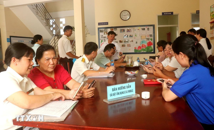 Cán bộ ngành thuế hướng dẫn người dân cài đặt ứng dụng eTax Mobile.