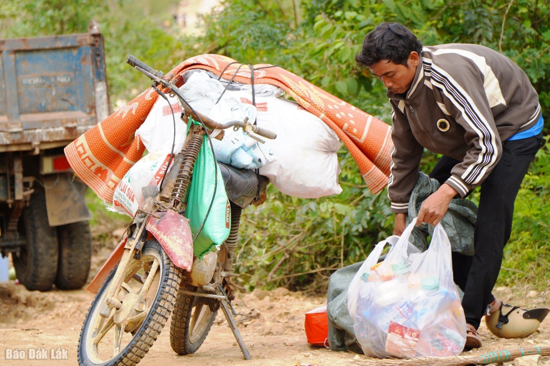 Sau khi nhận được hàng cứu trợ, người dân đưa hết lên xe máy chuẩn bị đưa về làng. Ảnh: Nhật Huy